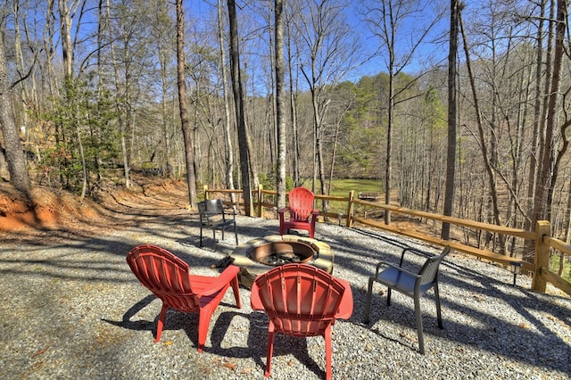 view of yard with a patio area, an outdoor fire pit, and a view of trees