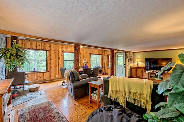 bedroom featuring light wood-type flooring, a textured ceiling, and multiple windows