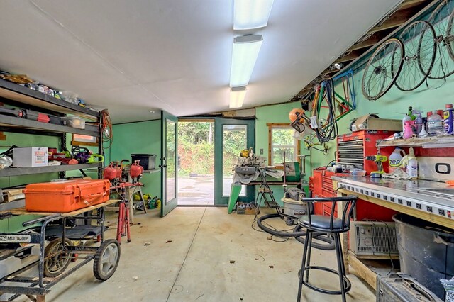 miscellaneous room featuring lofted ceiling, a workshop area, and concrete floors