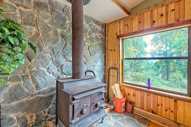 interior space featuring wooden walls and a wood stove