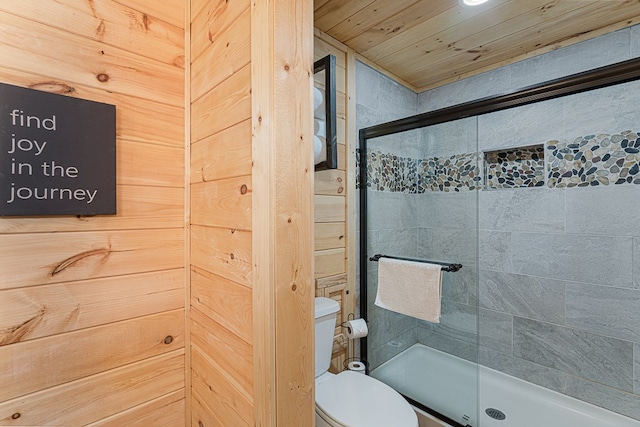 bathroom featuring a shower with shower door and toilet