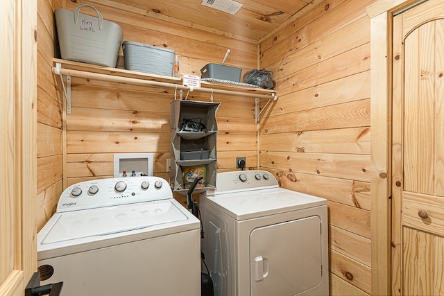 laundry area featuring wood ceiling, washer and clothes dryer, and wood walls