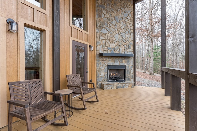 wooden deck with an outdoor stone fireplace