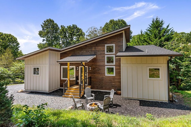 rear view of property with an outdoor fire pit