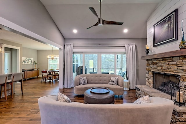 living room featuring a stone fireplace, plenty of natural light, lofted ceiling, and hardwood / wood-style flooring