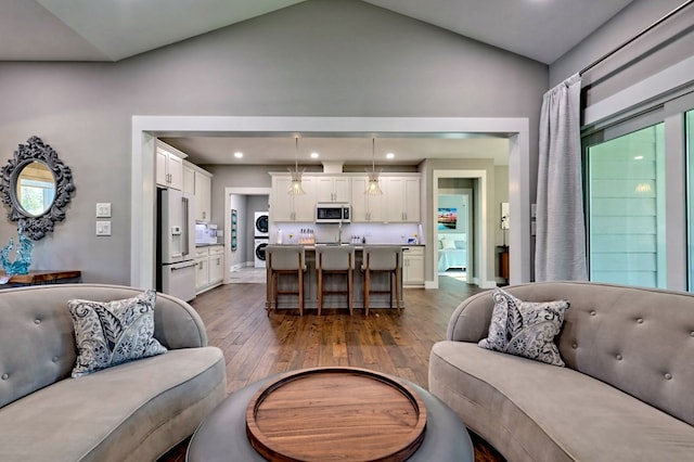 living room featuring washer / clothes dryer, sink, high vaulted ceiling, and dark wood-type flooring