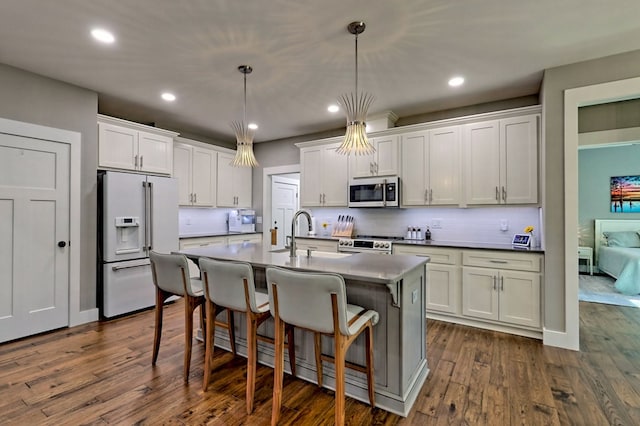 kitchen with pendant lighting, dark hardwood / wood-style flooring, white cabinets, and appliances with stainless steel finishes