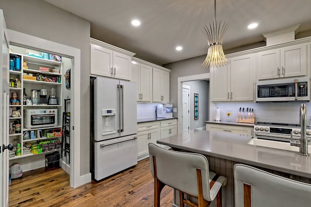 kitchen featuring white cabinets, appliances with stainless steel finishes, backsplash, and dark hardwood / wood-style floors