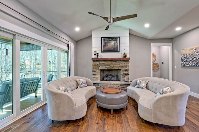 living room with hardwood / wood-style floors, a stone fireplace, ceiling fan, and lofted ceiling