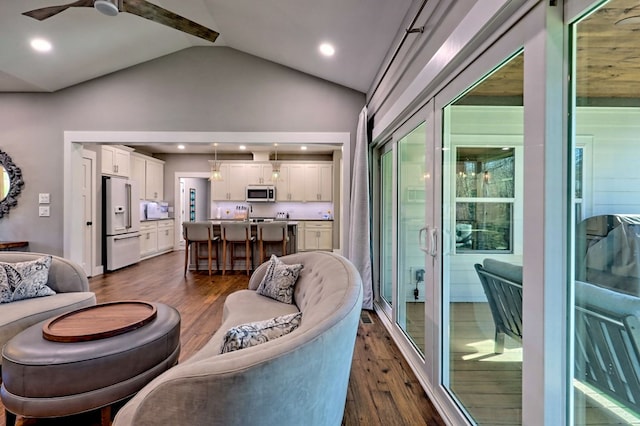 living room featuring ceiling fan, dark hardwood / wood-style floors, and vaulted ceiling