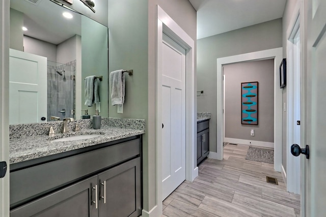 bathroom featuring vanity and tiled shower