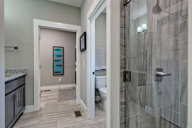 bathroom with walk in shower, hardwood / wood-style flooring, vanity, and toilet