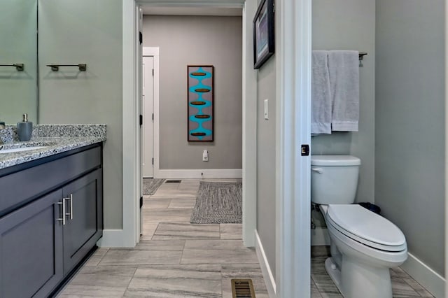 bathroom featuring hardwood / wood-style floors, vanity, and toilet