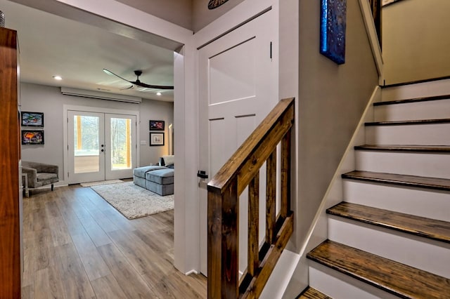 stairs featuring hardwood / wood-style floors, ceiling fan, and french doors