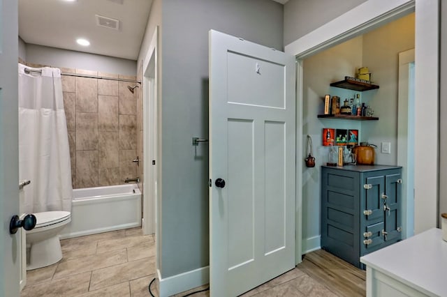 bathroom with shower / bath combo with shower curtain and toilet