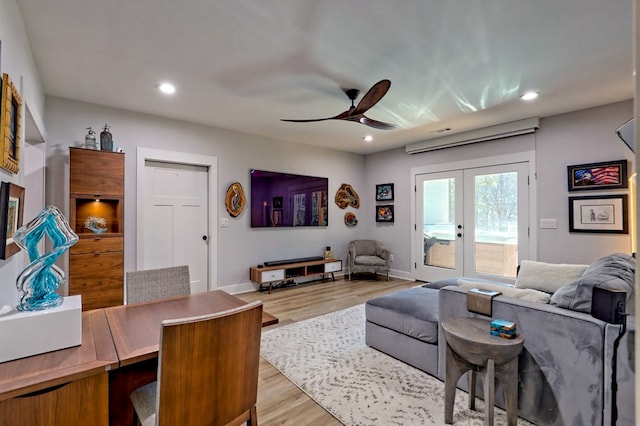 living room featuring french doors, light wood-type flooring, and ceiling fan