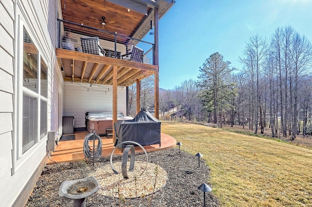 view of yard with a balcony and a hot tub