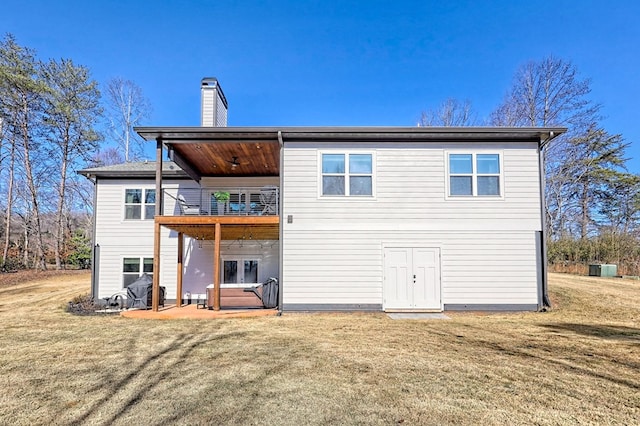 back of property featuring a patio area, a yard, and a balcony