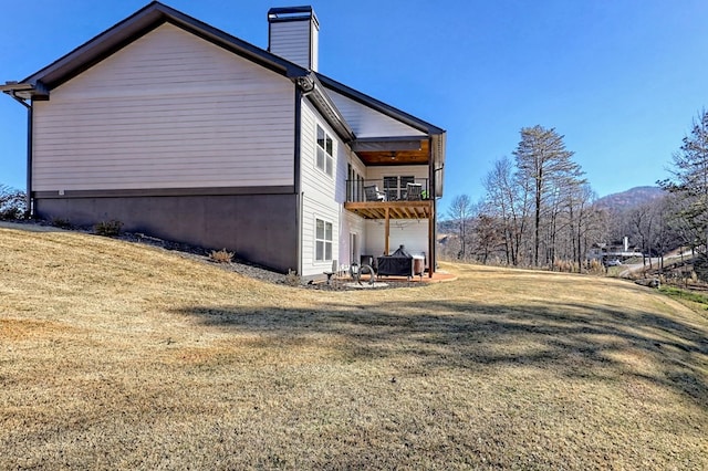 view of home's exterior with a lawn and a balcony