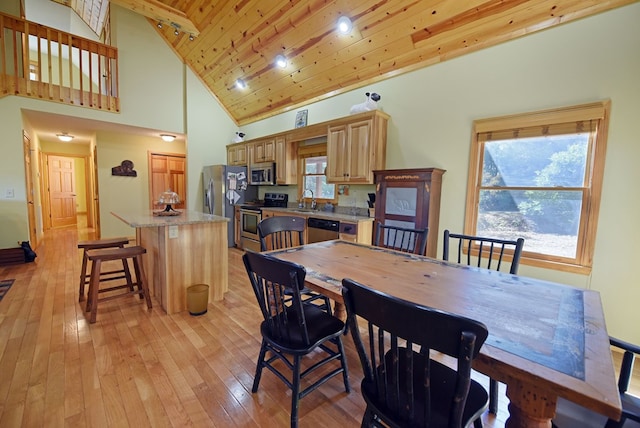 dining area with light hardwood / wood-style flooring, high vaulted ceiling, wooden ceiling, and sink