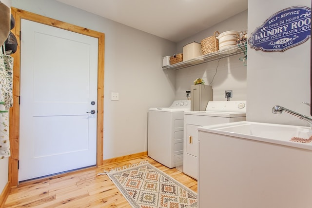 laundry room with light wood-type flooring and washer and dryer