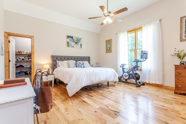 bedroom with ceiling fan, vaulted ceiling, and light hardwood / wood-style floors