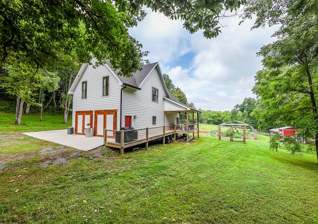 back of property featuring a wooden deck and a lawn