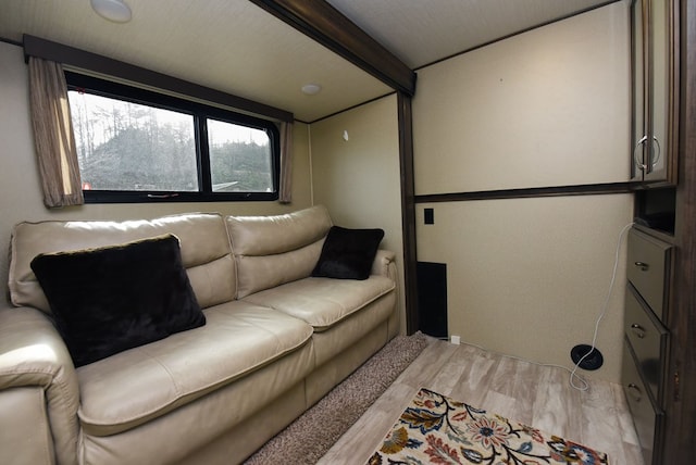 living room with beamed ceiling and light wood-type flooring