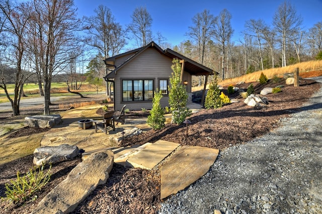 rear view of property with a fire pit