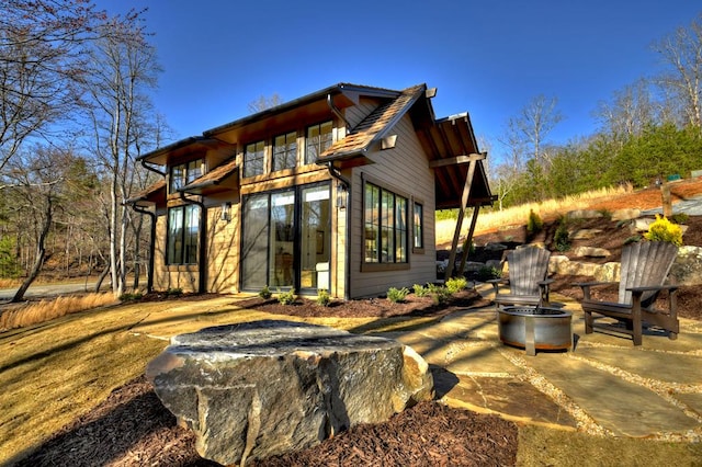 back of property featuring a patio and a fire pit