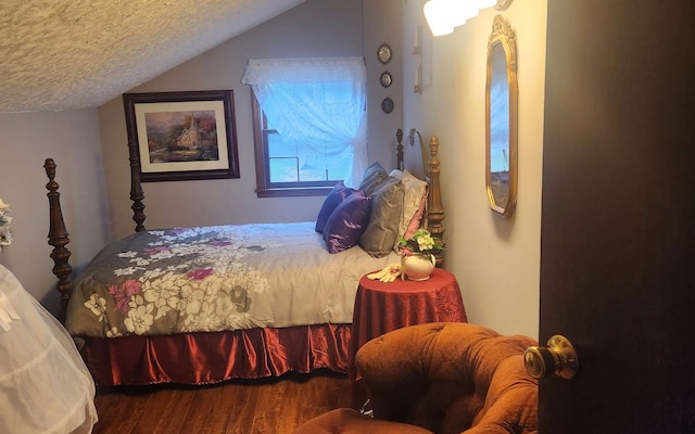bedroom featuring wood finished floors, lofted ceiling, and a textured ceiling