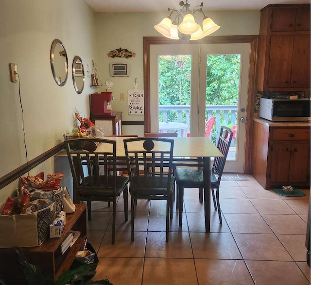 dining area featuring a chandelier, light tile patterned flooring, and an AC wall unit