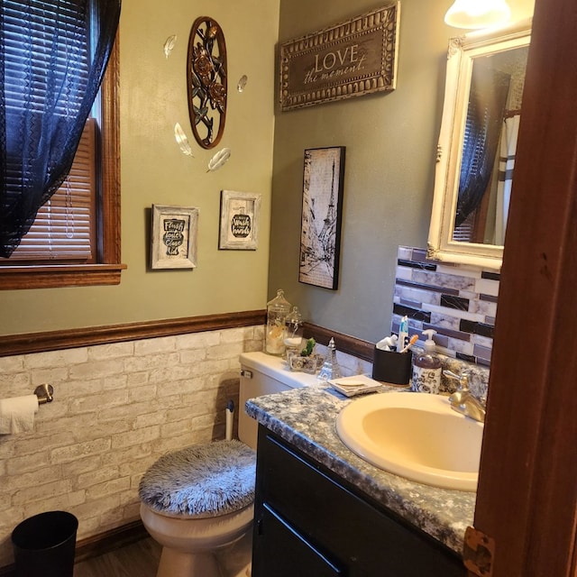 half bathroom featuring toilet, wainscoting, vanity, and wood finished floors