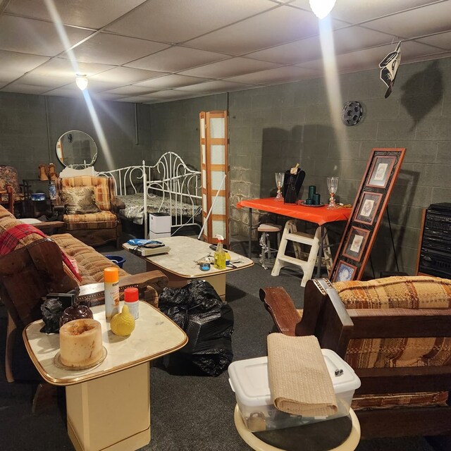 miscellaneous room with concrete block wall and carpet flooring