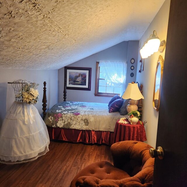 bedroom featuring vaulted ceiling, wood finished floors, and a textured ceiling