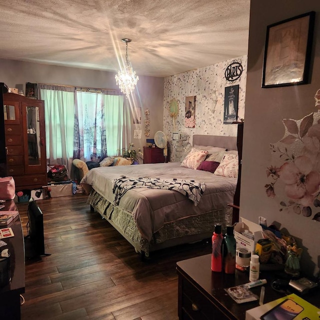 bedroom with dark wood-style flooring, a chandelier, wallpapered walls, and a textured ceiling