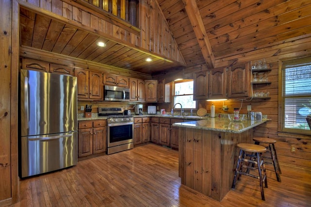 kitchen featuring wooden walls, wooden ceiling, stainless steel appliances, and dark hardwood / wood-style floors