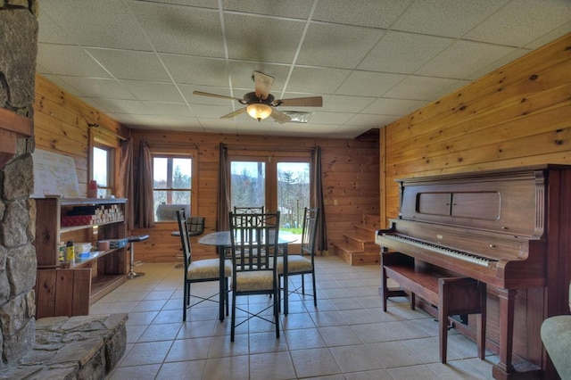 dining area featuring light tile flooring, ceiling fan, and a paneled ceiling