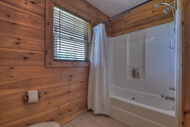 bathroom with wooden walls, a healthy amount of sunlight, shower / tub combo with curtain, and tile flooring