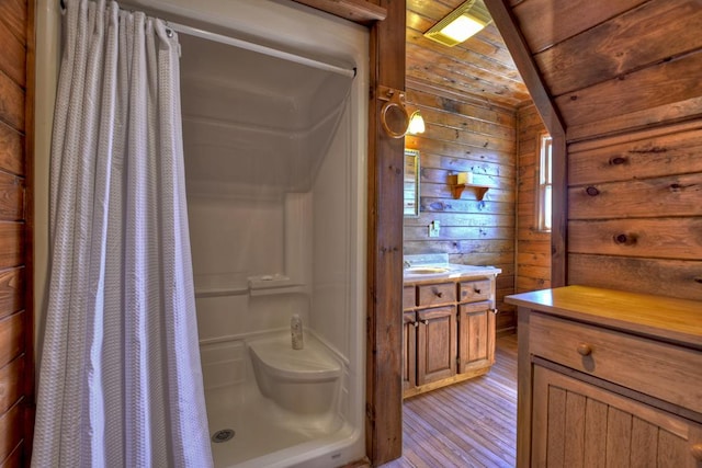 bathroom with vanity, wood walls, vaulted ceiling, wood ceiling, and hardwood / wood-style flooring