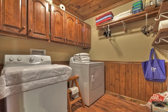 clothes washing area with dark hardwood / wood-style flooring, wooden ceiling, separate washer and dryer, washer hookup, and cabinets