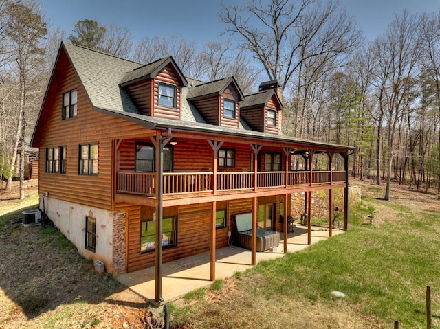 view of front of house featuring central air condition unit, a front yard, and a patio area