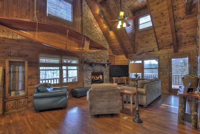 living room featuring dark hardwood / wood-style flooring, ceiling fan, and a healthy amount of sunlight