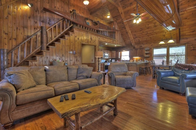 living room featuring dark hardwood / wood-style flooring, ceiling fan, wooden ceiling, and wooden walls