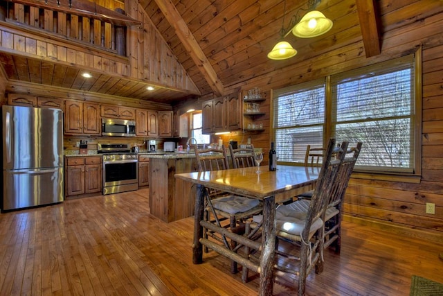 dining area with dark wood-type flooring, high vaulted ceiling, sink, wood walls, and wood ceiling