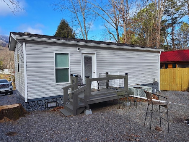 back of house with cooling unit and a wooden deck