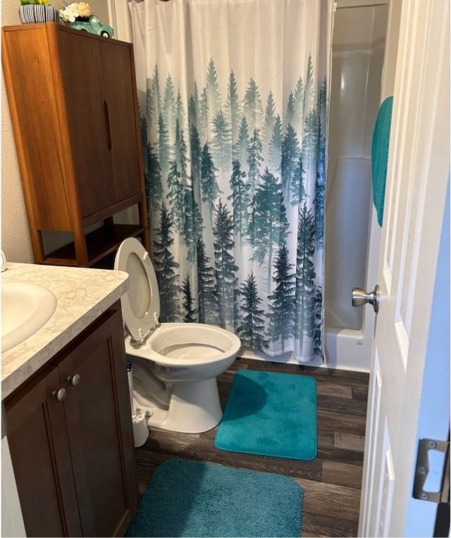 full bathroom with hardwood / wood-style floors, toilet, vanity, and shower / bath combination with curtain