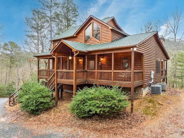 log cabin with covered porch and central AC unit