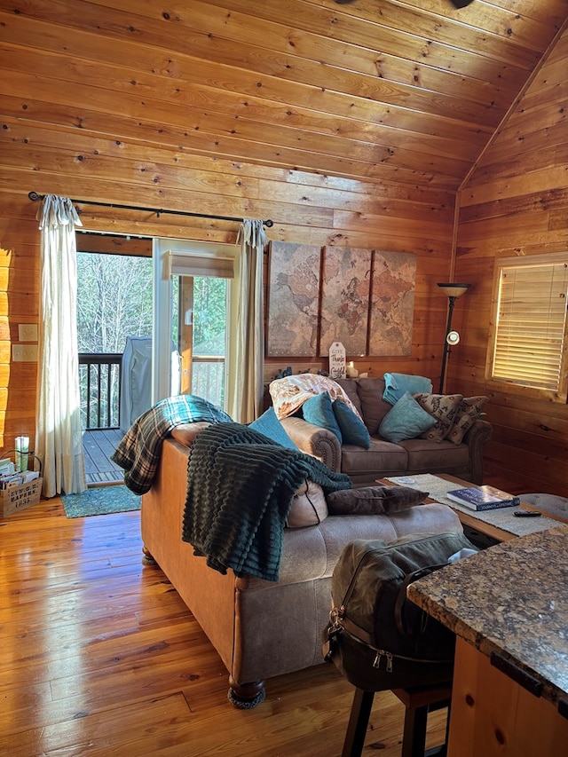 bedroom featuring light wood-style floors, wood ceiling, wooden walls, vaulted ceiling, and access to outside