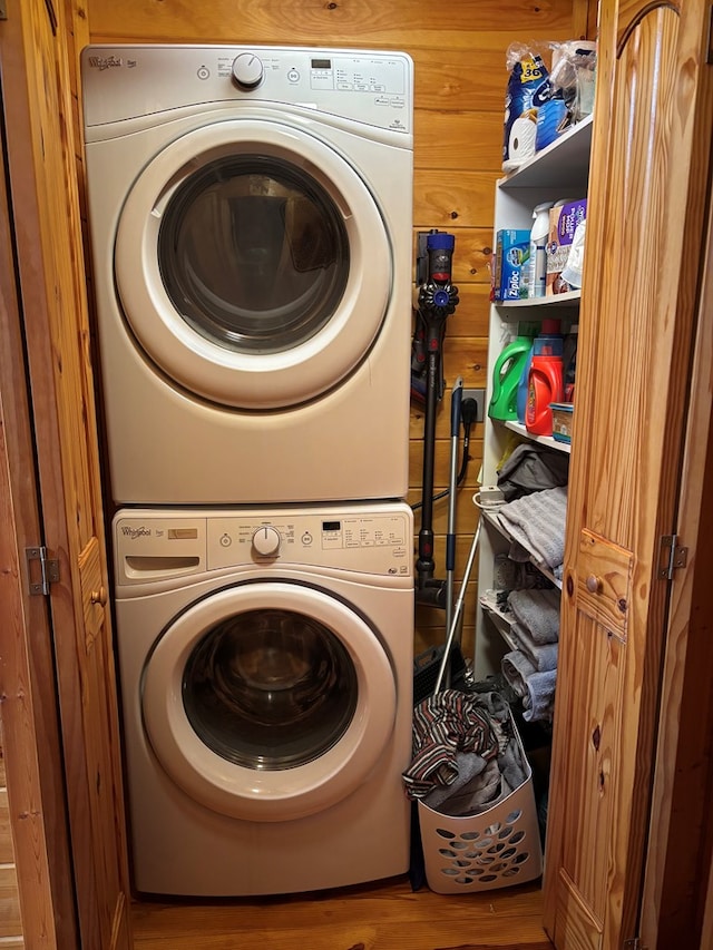 washroom with laundry area, wood finished floors, and stacked washer / drying machine